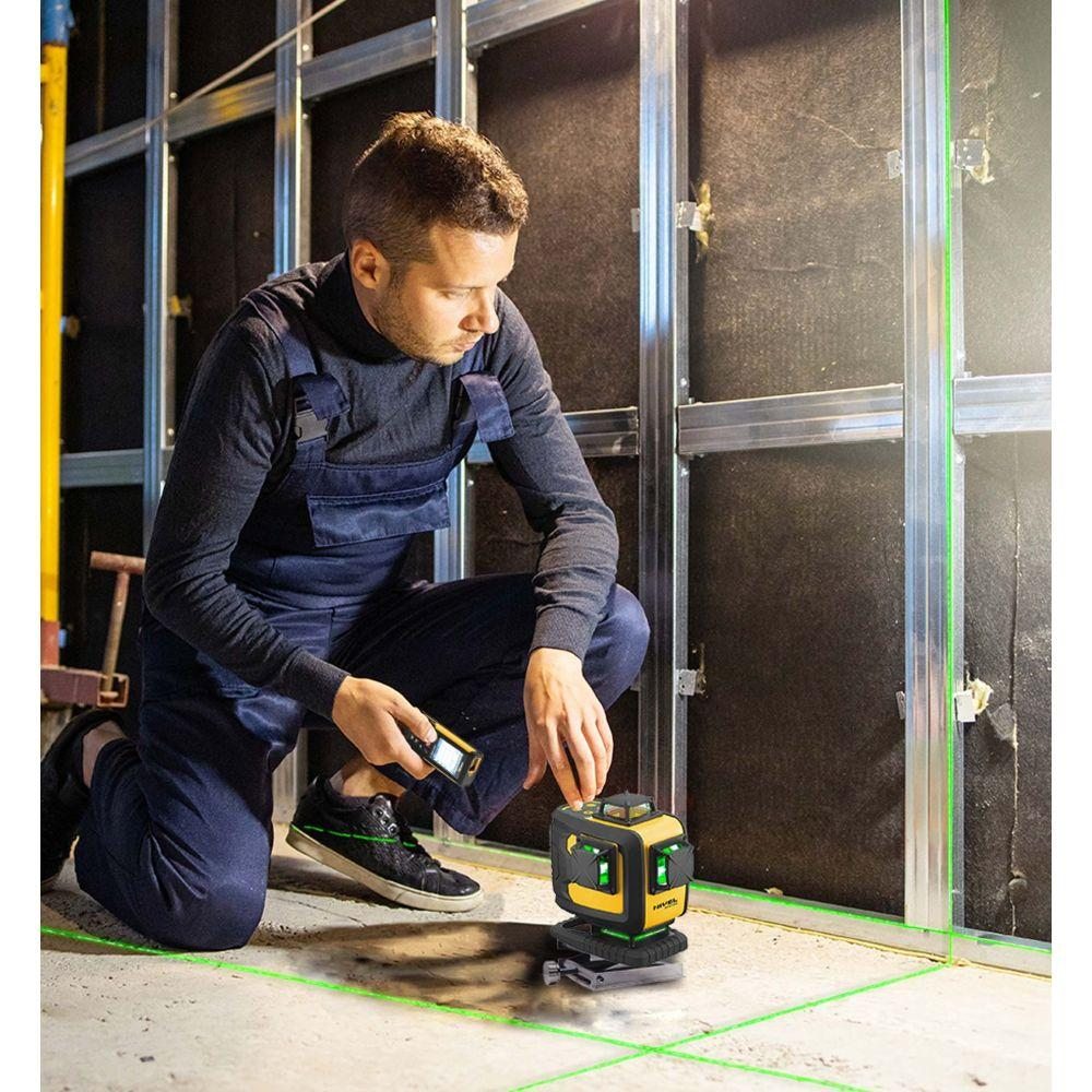 Remeselník používa krížový laser Nivel System pri montáži priečok